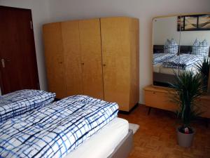 a bedroom with two beds and a dresser and a mirror at Apartment Nelli in Albstadt