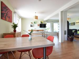 a dining room with a table and red chairs at Spacious Holiday Home in Hornstorf with Trampoline in Hornstorf