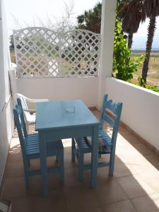 a blue table and two chairs on a porch at Mariliza Beach Hotel in Marmari