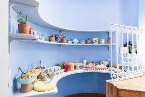 una habitación con paredes azules y estanterías llenas de comida en Salotto Monti, en Roma