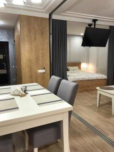 リヴィウにあるLUX Apartment Ruskaのダイニングテーブルとベッドルームが備わります。