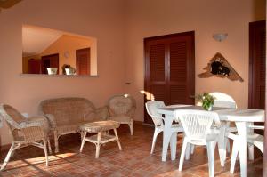a dining room with white tables and chairs at Residence Luna Rossa in Costa Rei