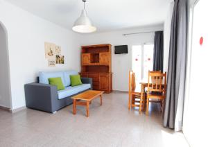 a living room with a blue couch and a table at Apartamentos Marian in San Antonio