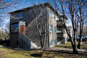 uma casa com um banco à frente em Igdlo Guesthouse em Reykjavík