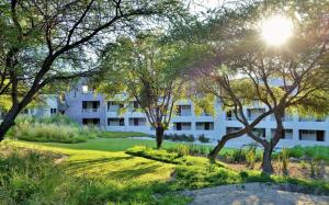 a building with the sun shining through trees at Cresta Maun Hotel in Maun