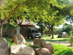 un jeep estacionado frente a una casa con árboles y rocas en Augrabies Falls Lodge & Camp, en Augrabies