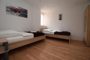 two beds in a room with wooden floors at Apartment Stuttgart Ost in Stuttgart