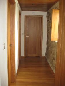 a hallway with a wooden door and a stone wall at Ares do Montemuro in Campo Benfeito