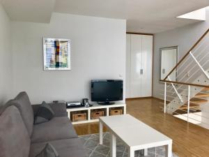 Una sala de estar con un sofá y un televisor. en Mini-Reihenhaus "Alte Buchdruckerei", en Heringsdorf