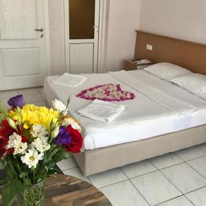 a bedroom with a bed with a vase of flowers at Cam Hotel in Fethiye
