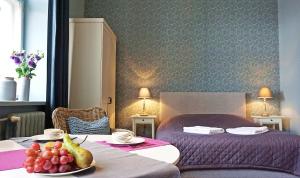 a hotel room with a bed and a table with a bowl of fruit at DK Apartament Romantyczny in Olsztyn