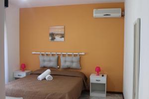 a bedroom with two beds and orange walls at Casa Chiarenza in Castellammare del Golfo