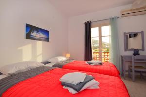 two red beds in a room with a window at Seagull Rooms in Galissas