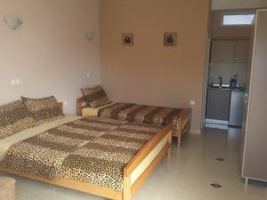 a bedroom with two beds and a kitchen with a refrigerator at Apartments Nasteski in Ohrid
