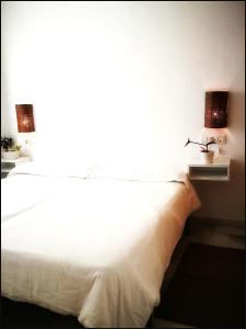 タリファにあるOneの白いベッド(上にランプ2つ付)