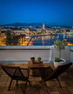 einen Balkon mit einem Tisch und Stühlen sowie Aussicht in der Unterkunft Belvedere Luxury Rooms - Breathtaking View in Split