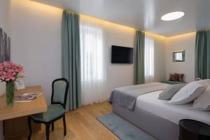a hotel room with a bed and a table and a desk at Belvedere Luxury Rooms - Breathtaking View in Split