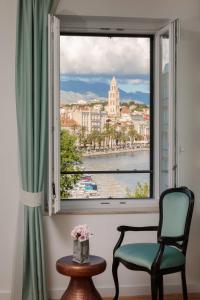 a window with a chair and a view of the water at Belvedere Luxury Rooms - Breathtaking View in Split