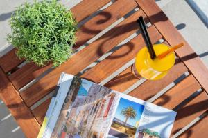 a table with a magazine and a drink on it at Belvedere Luxury Rooms - Breathtaking View in Split +26 photos