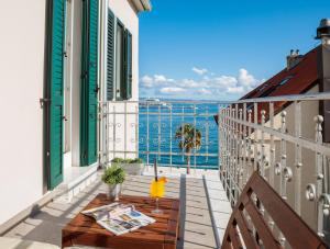 einen Balkon mit einem Tisch und Meerblick in der Unterkunft Belvedere Luxury Rooms - Breathtaking View in Split