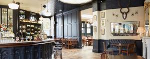 a restaurant with a bar and tables and chairs at The Princess Victoria in London