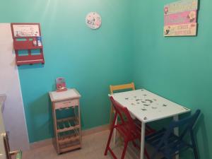 a table and chairs in a room with a blue wall at NOOR Apartment and Room in Hvar