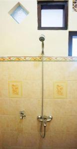 um chuveiro com uma mangueira na casa de banho com uma janela em Jeru Homestay em Situbondo