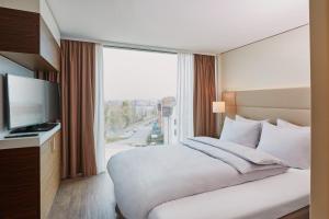 Rúm í herbergi á H4 Hotel Solothurn