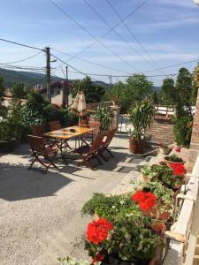 a patio with a table and chairs and flowers at Eva Rooms in Budakeszi