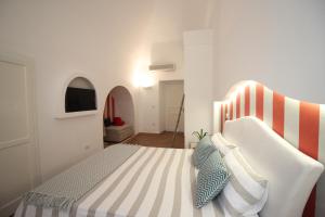 a bedroom with a bed with a striped headboard at S'O Smart B&B Tropea in Tropea