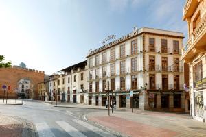 una strada con un edificio all'angolo di una strada di Exe Triunfo Granada a Granada