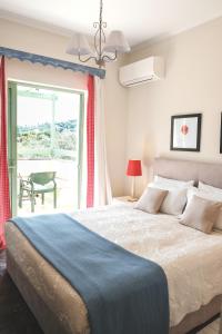 a bedroom with a large bed and a window at Isabella Country House in Gouvia +109 photos