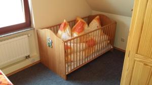 ein Kinderbett voller Babyartikel in einem Zimmer in der Unterkunft Ferienhaus Knappensee in Lohsa