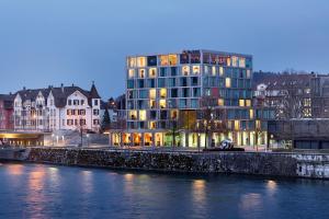 um edifício alto ao lado de um rio com edifícios em H4 Hotel Solothurn em Solothurn