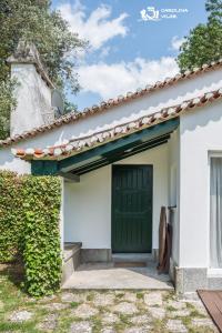 uma casa branca com uma porta verde em The Gate House em Bucelas