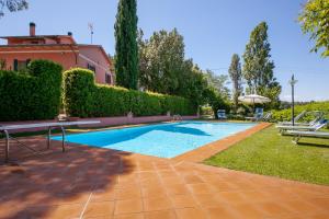 a swimming pool in the yard of a house at Podere Lo Stringaio in Fauglia