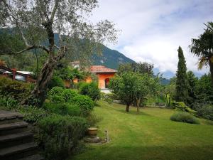 un patio con una casa en el fondo con árboles en Bellagio Lake View Villa, en Oliveto Lario
