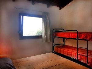 a bedroom with two bunk beds and a window at villa Magritte in Stintino