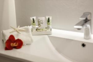 a bathroom with a sink with towels and a red flower at S'O Smart B&B Tropea in Tropea