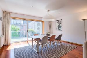 a dining room with a table and chairs and a large window at Pretty Porto Apartment by SOULSHARING.PORTO in Porto