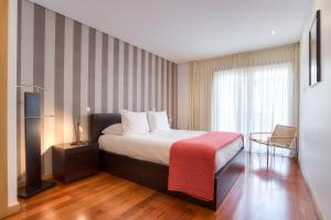 a hotel room with a bed and a window at Pretty Porto Apartment by SOULSHARING.PORTO in Porto