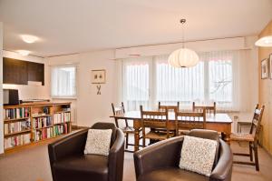 Apartment Schönegg - GRIWA RENT AG في جريندلفالد: غرفة طعام وغرفة معيشة مع طاولة وكراسي