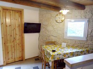 a dining room with a table and a clock on the wall at La Dimora di Angela in Ragusa