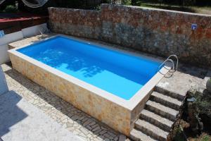 - une piscine avec un mur en pierre et des escaliers dans l'établissement Apartments Seka, à Risika