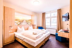 ein Hotelzimmer mit einem Bett mit einem Gemälde an der Wand in der Unterkunft Hotel Am Alten Hafen in Wismar