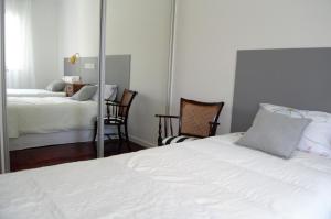 a bedroom with a white bed and a mirror at Apart. Madeira 4 you in Funchal