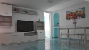 a living room with a flat screen tv and a table at Casa Cucurullo in Procida
