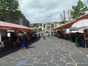 a group of people walking through a market with umbrellas at Joli studio calme avec terrasse in Nice