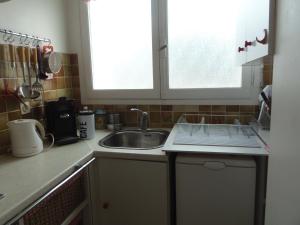 a kitchen with a sink and a counter top at Joli studio calme avec terrasse in Nice