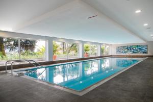 - une grande piscine dans un bâtiment doté de fenêtres dans l'établissement Tertianum Residenza Hotel & Ristorante Al Parco, à Locarno